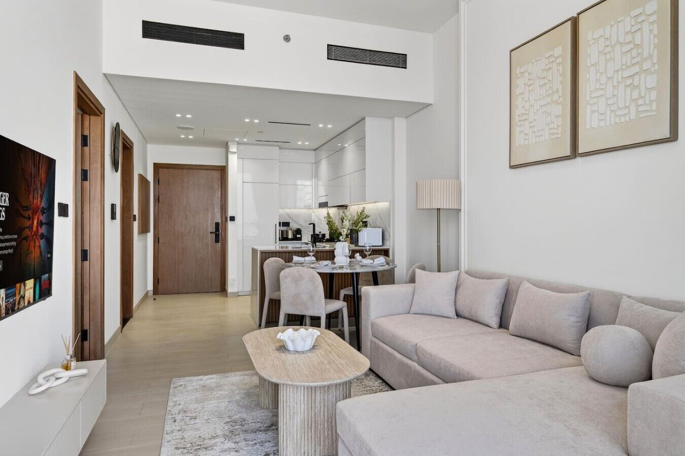 A modern living room with a sofa, a coffee table, and a dining area with chairs and a table.