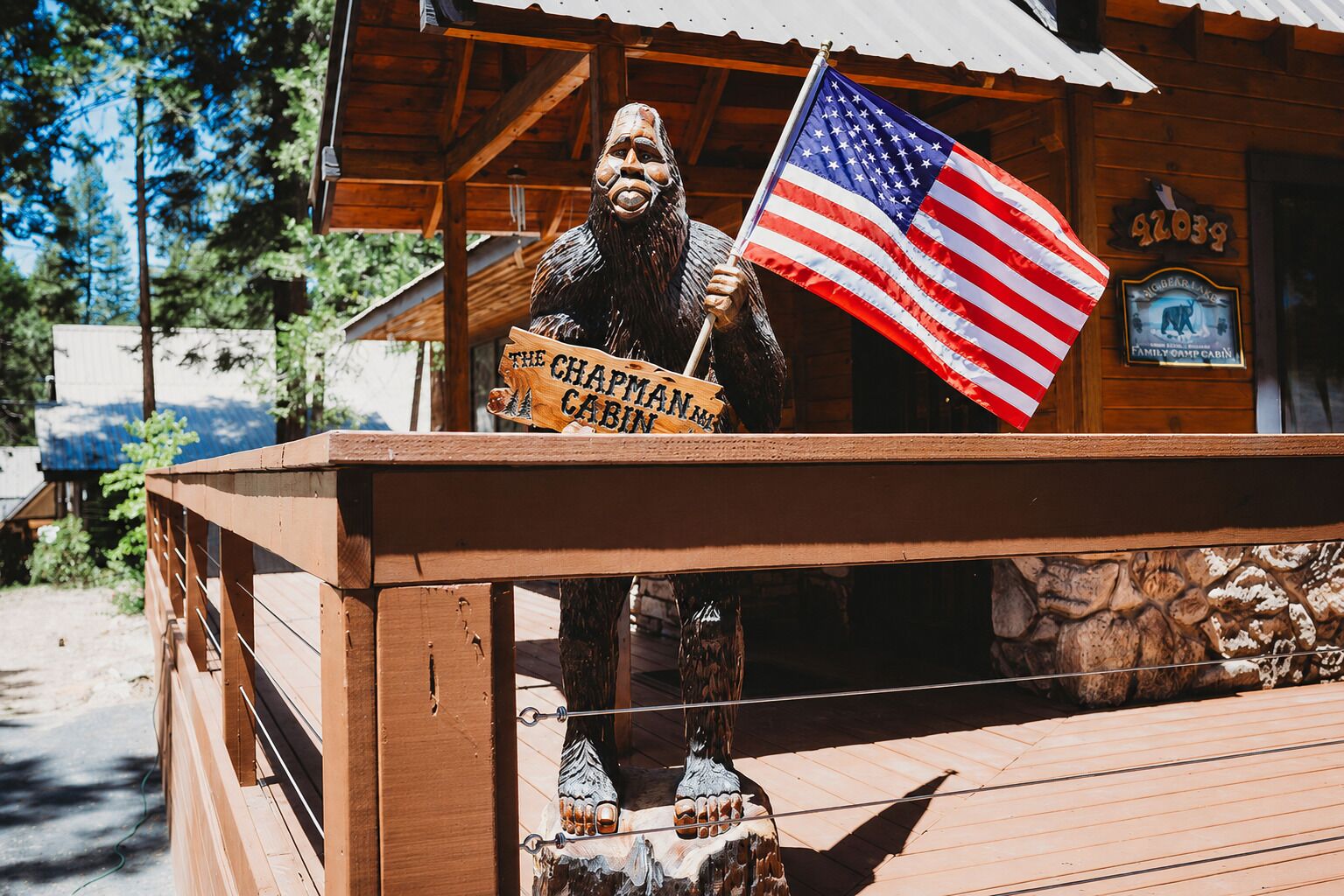 Een houten hutje met een bord waarop 'The Chapman Cabin' staat en een Amerikaanse vlag.