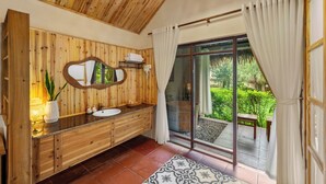 A wooden bathroom with a large mirror, sink, and wooden cabinets. - Cuc Phuong Mineral Retreat (Cuc Phuong)