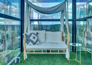 Una habitación con una cama, una mesita y vistas al exterior.