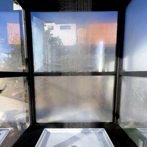 A window with a view of a building and containers.