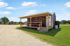 A small wooden building with a porch, a sign indicating it's a guest house, and a 'No Parking' sign. - Charming Riverside Cabin Escape with Outdoor Relaxation Spaces in Medina, Texas (Medina)