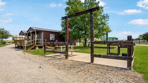 A rustic wooden structure with a porch and steps leading to a house. - Charming Riverside Cabin Escape with Outdoor Relaxation Spaces in Medina, Texas (Medina)