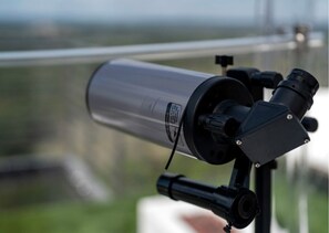 A telescope mounted on a tripod with a blurred background. - Modern Dome Escape with Private Decks & Open-Sky Relaxation in Cottonwood, Texas (Cottonwood Shores)