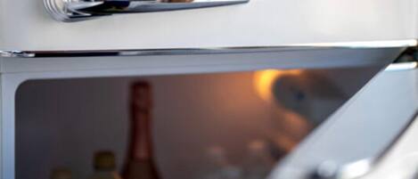 Un refrigerador con manija metálica y puerta de vidrio.