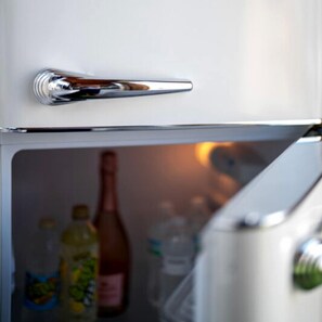 Un refrigerador con manija metálica y puerta de vidrio.