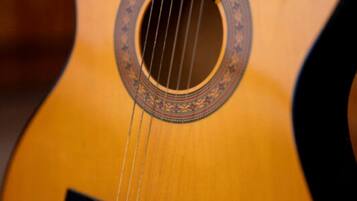A close-up of a guitar's sound hole with a decorative rosette.