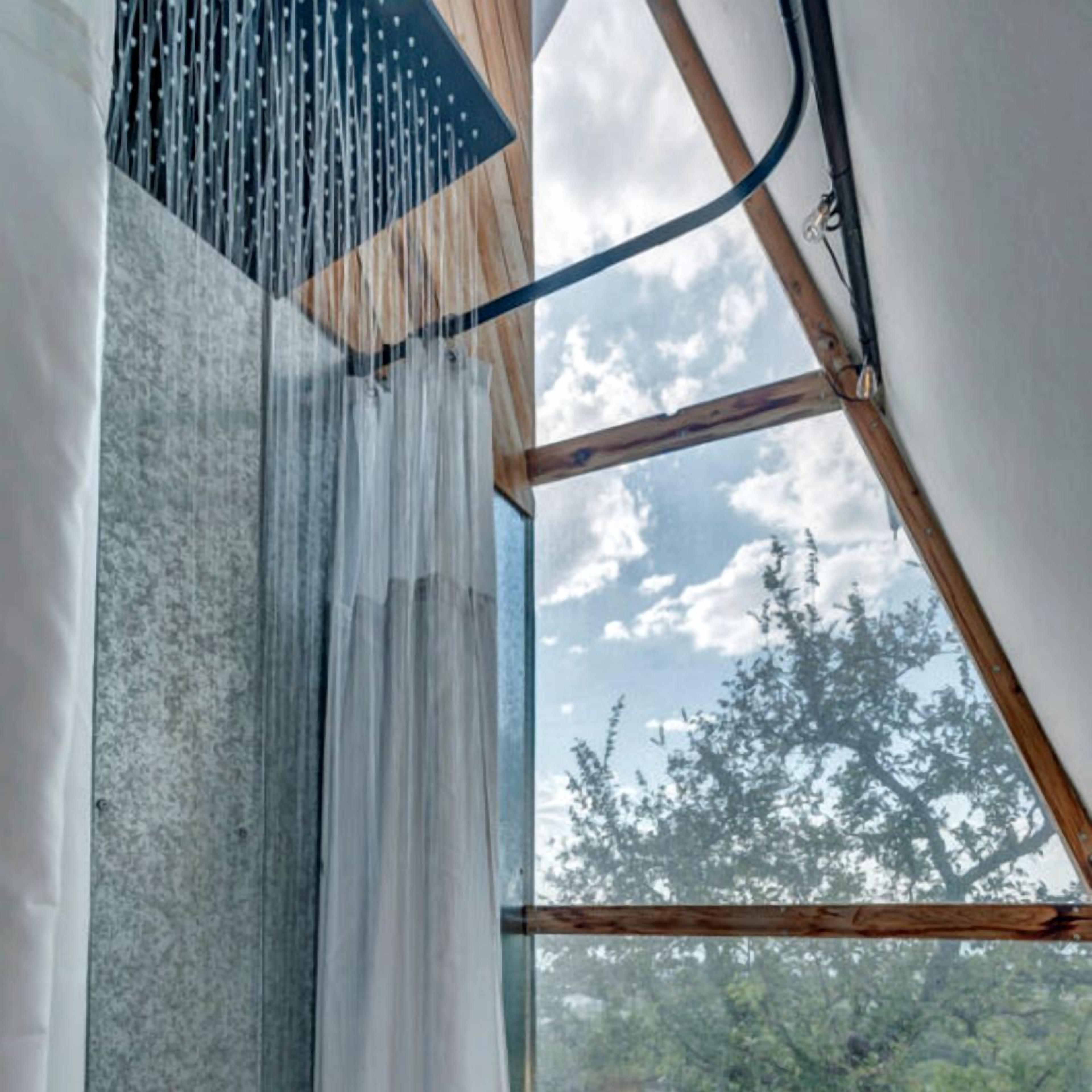 Ein Zimmer mit großem Fenster, Holzbalken und einem Vorhang.
