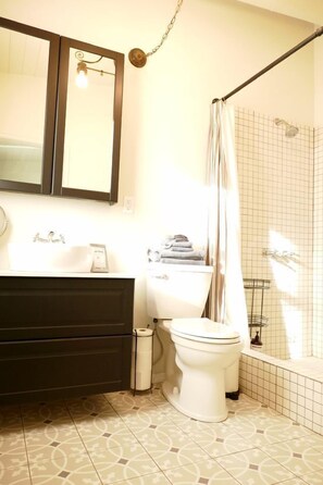 Een badkamer met toilet, wastafel en douche.