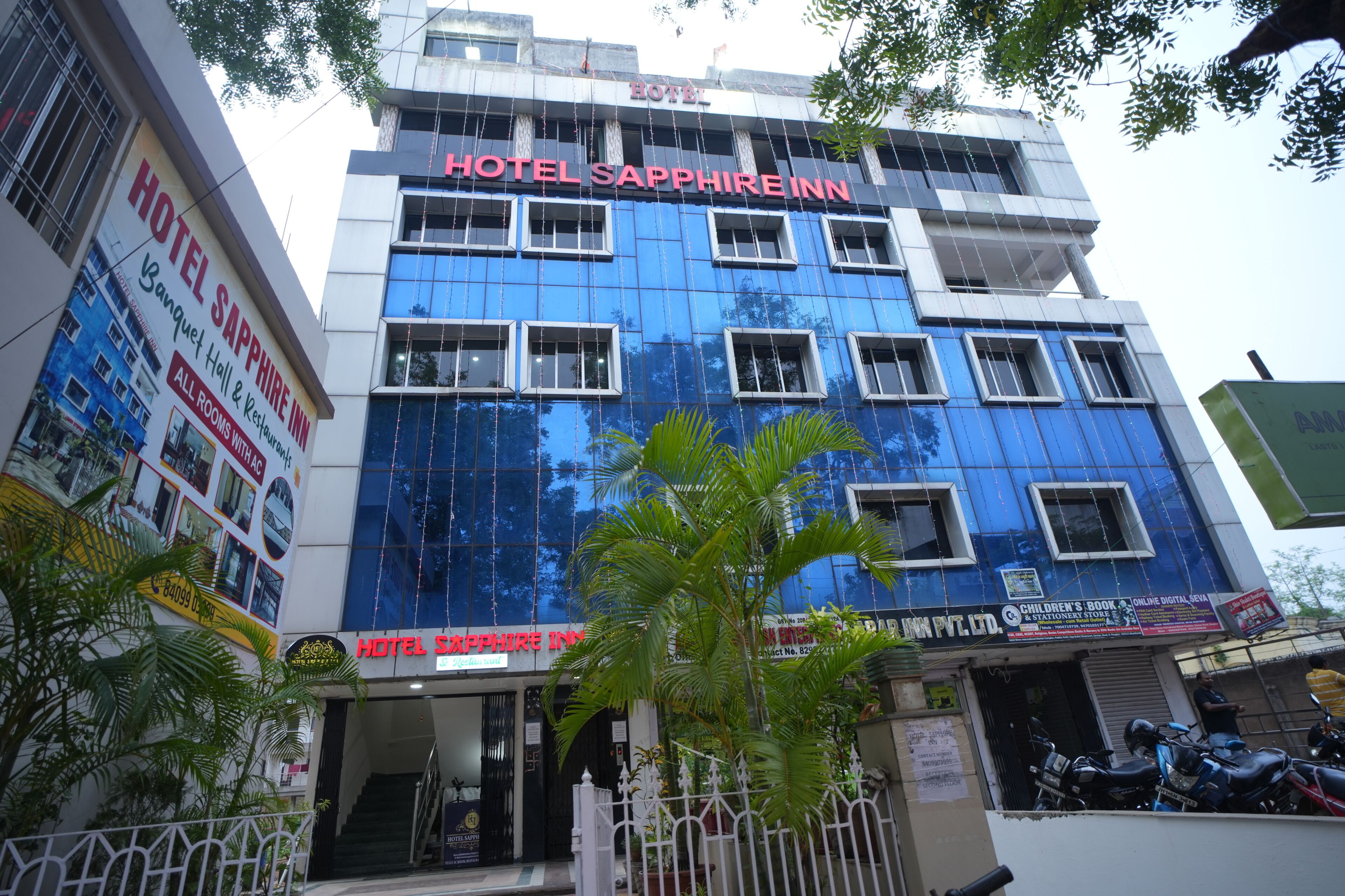 A multi-story building with a prominent sign for Hotel Sapphire Inn.