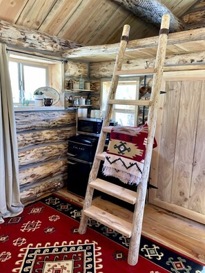 A wooden interior with a ladder, a microwave, and a patterned rug. - Serene Western Cabin with 23 Private Acres & Stargazing Near Zion National Park, Mount Carmel, Utah (Mount Carmel)