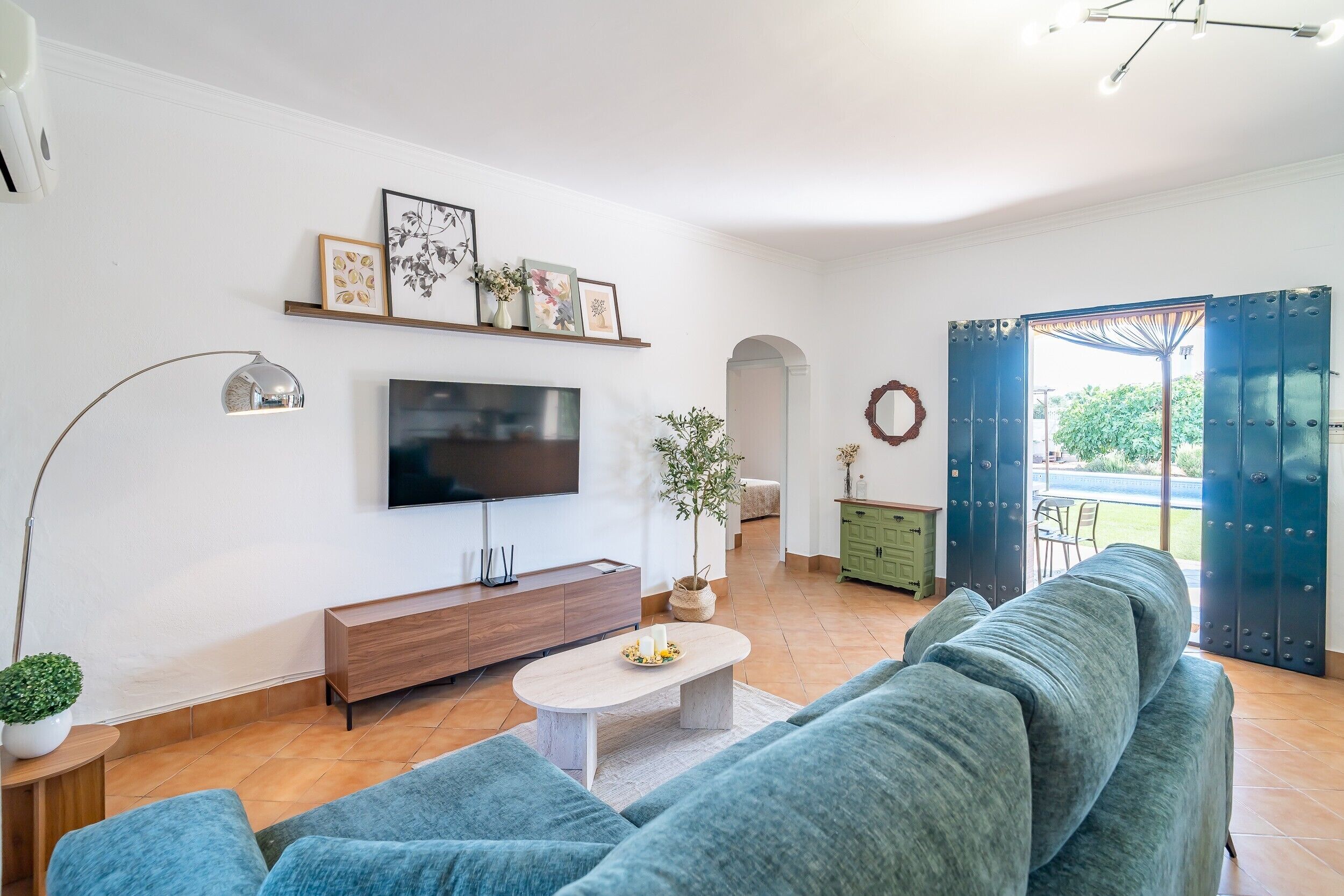 Una sala de estar moderna con un sofá, televisión y adornos en la pared.