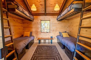 A cabin with bunk beds, a small table, and a window. - All-Inclusive Mountain Cabin Retreat with Chef & Epic Alpine Views in Truckee, California (Truckee)