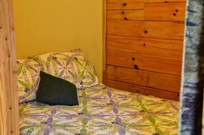 A small bed with a floral-patterned bedspread and a dark pillow. - Cozy Log Cabin for Getaway in the Mountains near Cherokee, North Carolina (Cherokee)