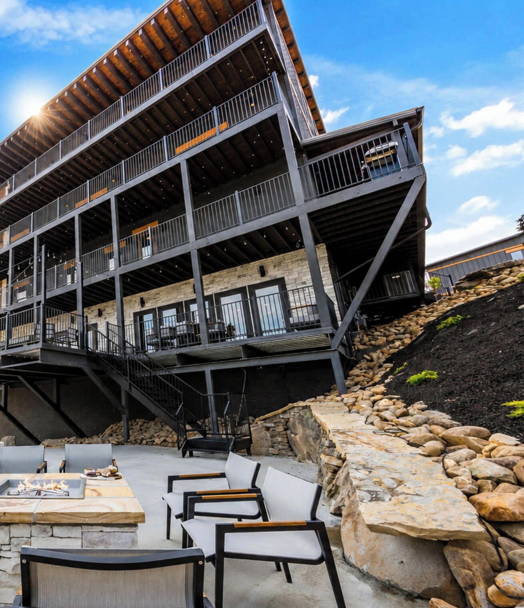 A multi-story building with outdoor seating and a fire pit.