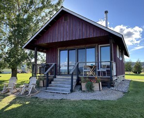 A rustic cabin with a porch, outdoor seating, and a chimney. - Luxury Flathead Lake Cabin with Stunning Views (Somers)