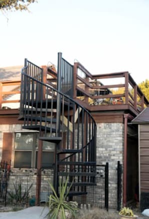 Ein modernes Gebäude mit einer Wendeltreppe, einer Backsteinmauer und einem Metallzaun.