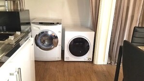 Una cocina compacta con microondas, lavadora y secadora.