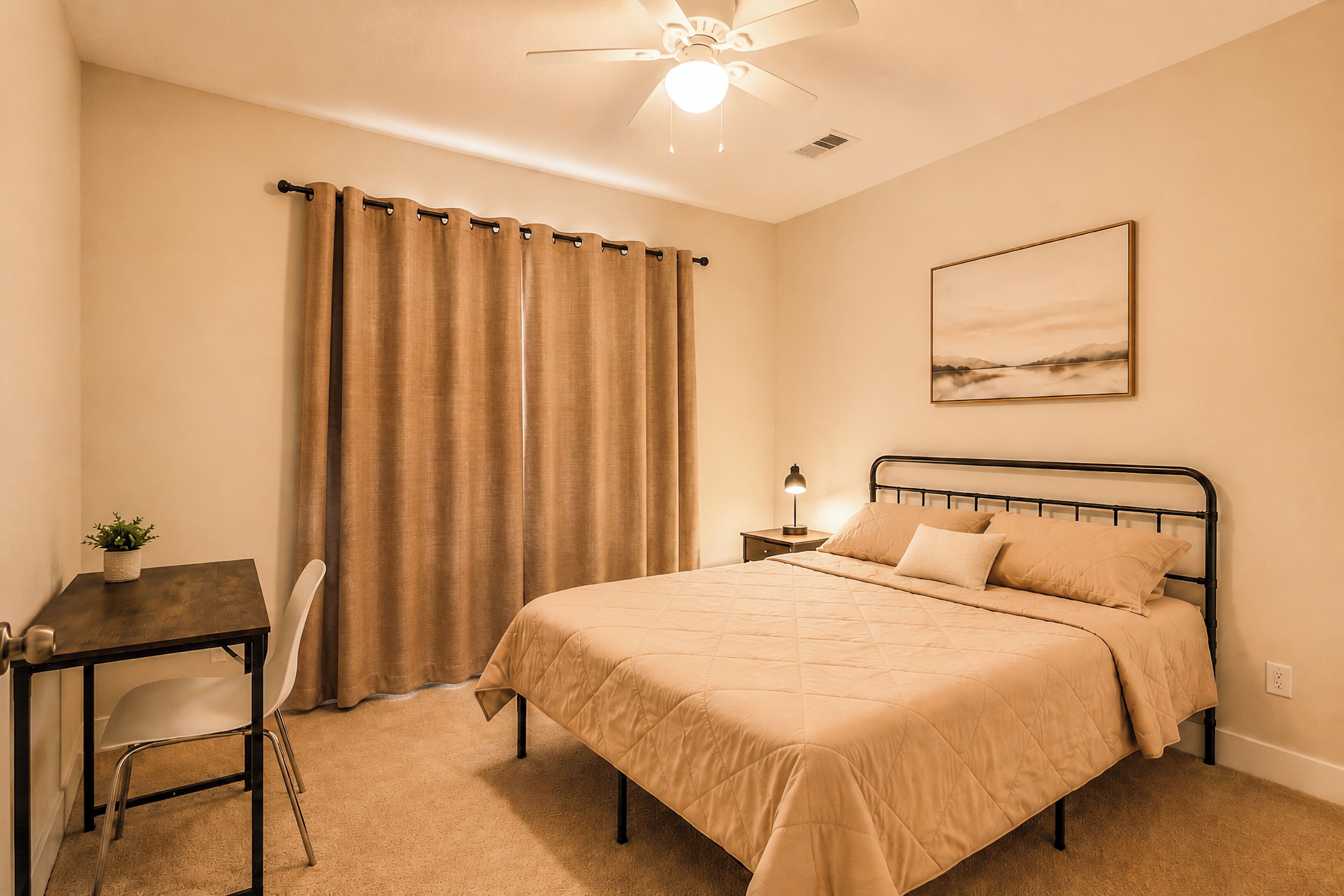 A bedroom with a bed, a desk, a chair, a ceiling fan, and a painting on the wall.
