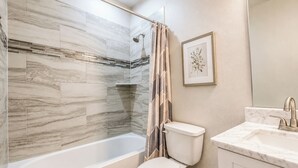 Un bagno con vasca, water e lavandino.