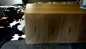 Ein gemütliches Schlafzimmer im Dachgeschoss mit einem Bett, einem Holzschrank, einem Ventilator und einem Kuhfellteppich.