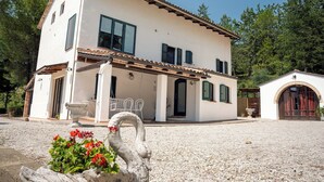 A two-story building with a white facade, a tiled roof, and a gravel driveway. - Villa Maline – Private Country Villa with a Jacuzzi and Sauna (Marche)
