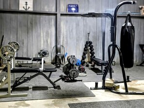 Ein Fitnessraum mit Krafttrainingsgeräten, Bänken und einem Squat-Gestell.