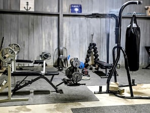 A gym with weightlifting equipment, benches, and a squat rack.