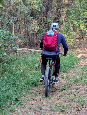Henkilö pyöräilee metsäpolulla.
