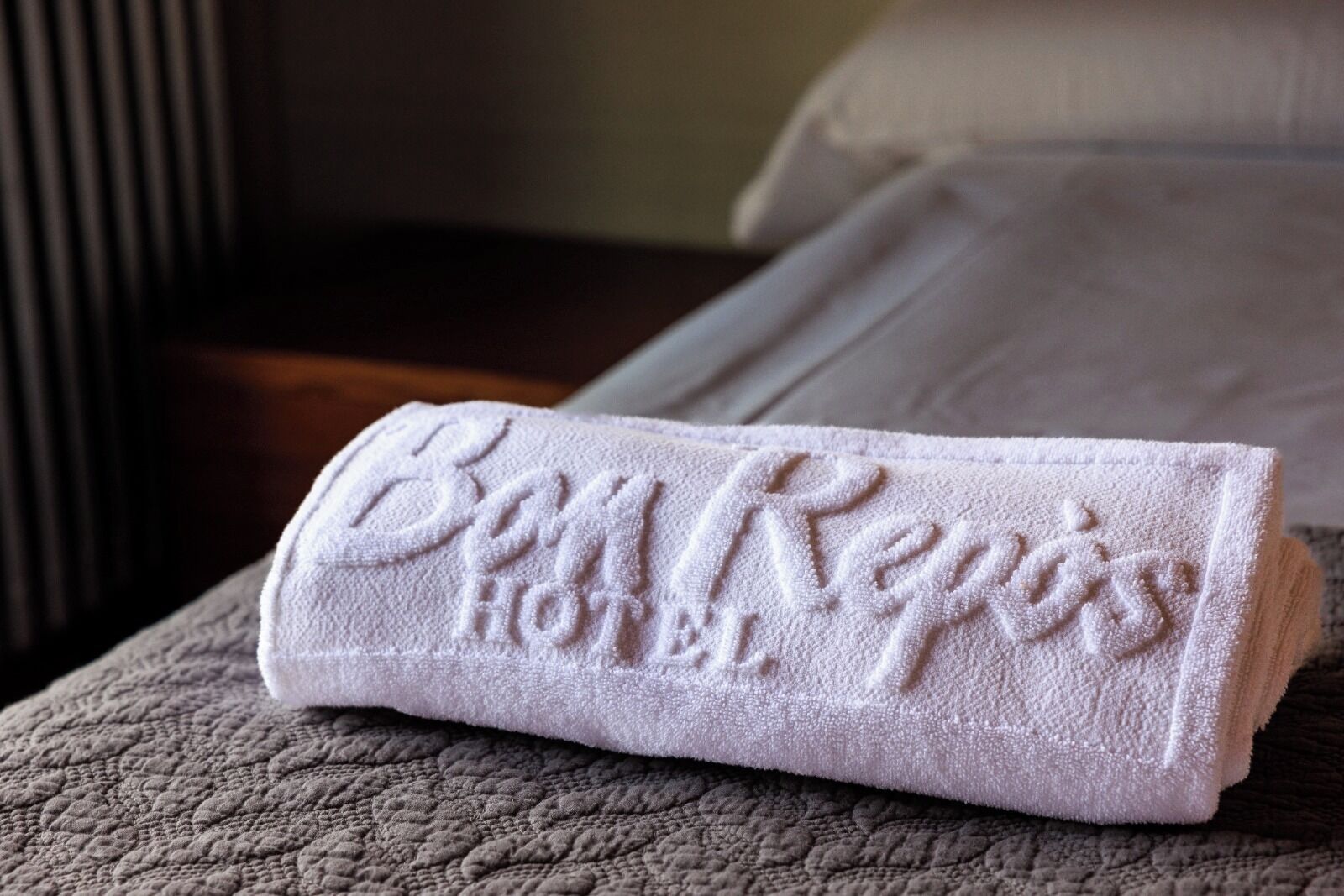 A neatly folded towel with embossed text on a textured surface.