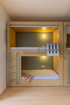 A bunk bed with a ladder, a small window, and a light fixture. - defaultName (Barcelona)