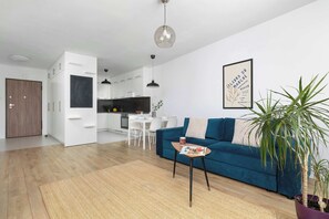 Ein modernes Wohnzimmer mit einer Couch, einem Couchtisch und einer Topfpflanze.