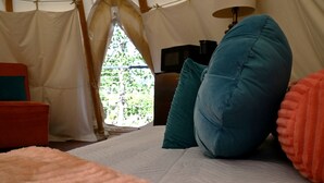 A tent with a bed, pillows, and a view of greenery outside. - Serene Teepee Escape with Soulful Ambiance in Salt Lick, Kentucky (Salt Lick)