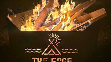 A campfire with a logo and text 'THE EDGE' below it.