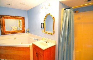 Un baño con bañera, lavamanos, espejo y cortina de ducha.