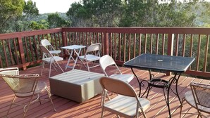 Une terrasse en bois aménagée avec du mobilier d’extérieur, notamment une table et des chaises.