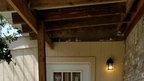 Une porte en bois avec un panneau blanc, une lanterne et un mur de briques.