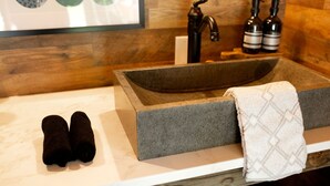 A bathroom with a stone sink, two towels, a faucet, and two bottles. - Peaceful Cabin Retreat with Spa Features & Unique Farm Vibes in Newport, Tennessee (Newport)