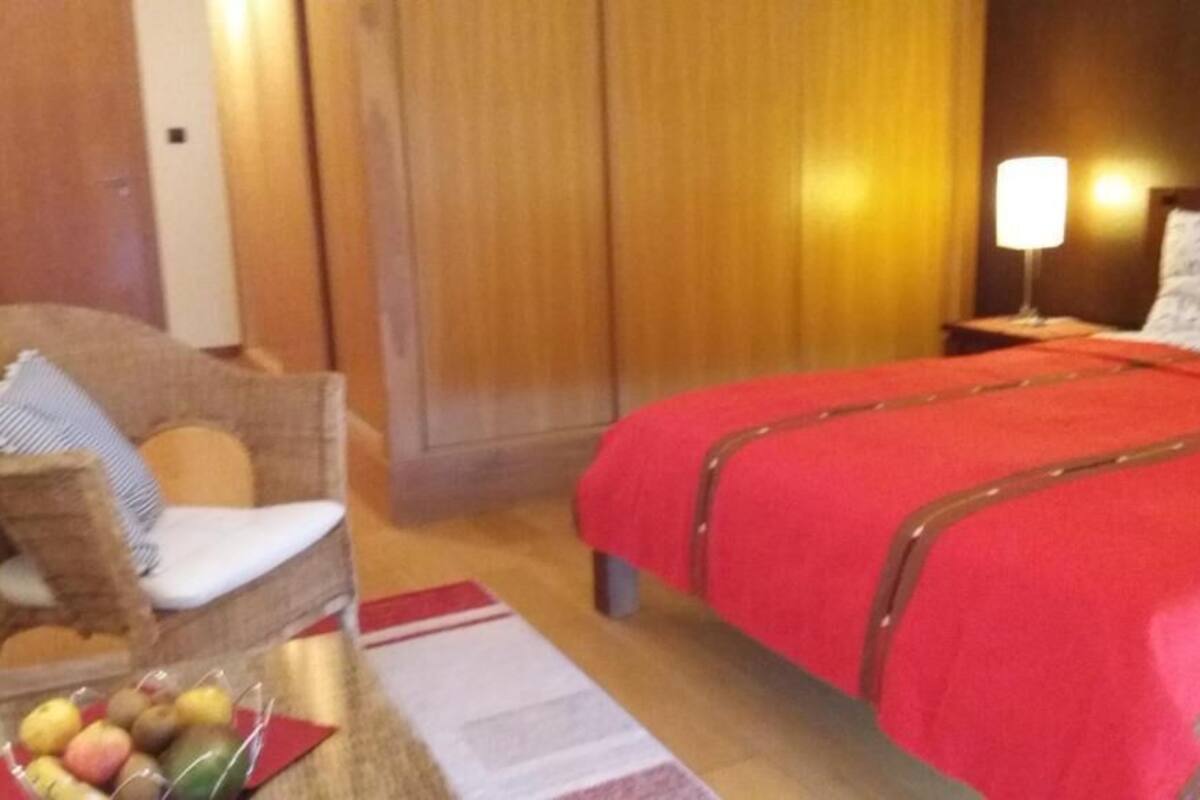 Ein Hotelzimmer mit Bett, Stuhl, Nachttisch und Lampe.
