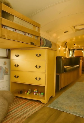 Un espacio habitable acogedor con un aparador de madera, un sofá y una mesita, todo dispuesto de forma confortable.