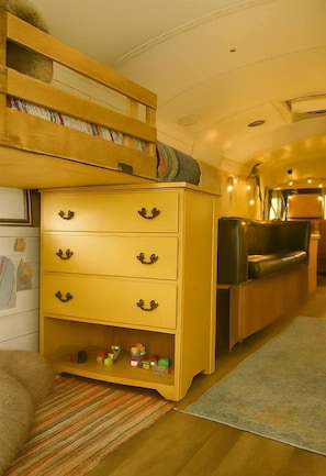 A compact living space with a wooden dresser, a sofa, and a small table, all arranged in a cozy interior.