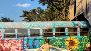 Un autobús colorido con grafitis, estacionado al aire libre.