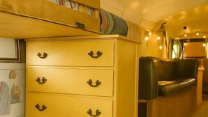 Un espacio habitable acogedor con un aparador de madera, un sofá y una mesita, todo dispuesto de forma confortable.