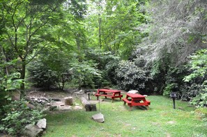 A forested area with picnic tables and a stone path. - Rustic Family-Friendly Log Cabin in the Smoky Mountains, North Carolina (Cherokee)