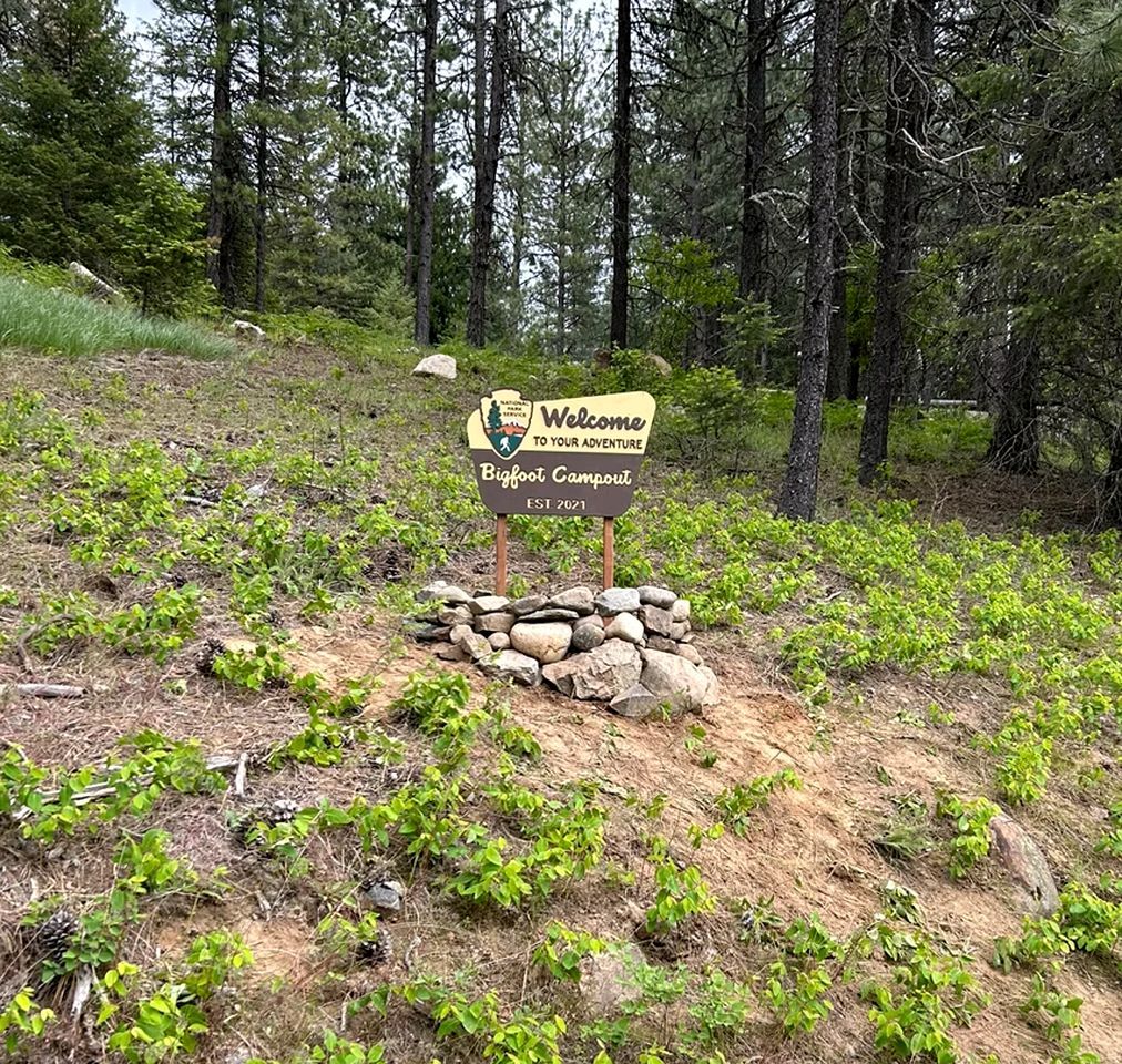 Señal de bienvenida al Bigfoot Campout en una zona boscosa.