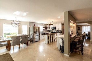 A modern kitchen with a central island, stainless steel appliances, and a dining area with bar stools. - Modern Villa with Sauna, Pool & Panoramic Views in Bushkill, Pennsylvania (Bushkill)