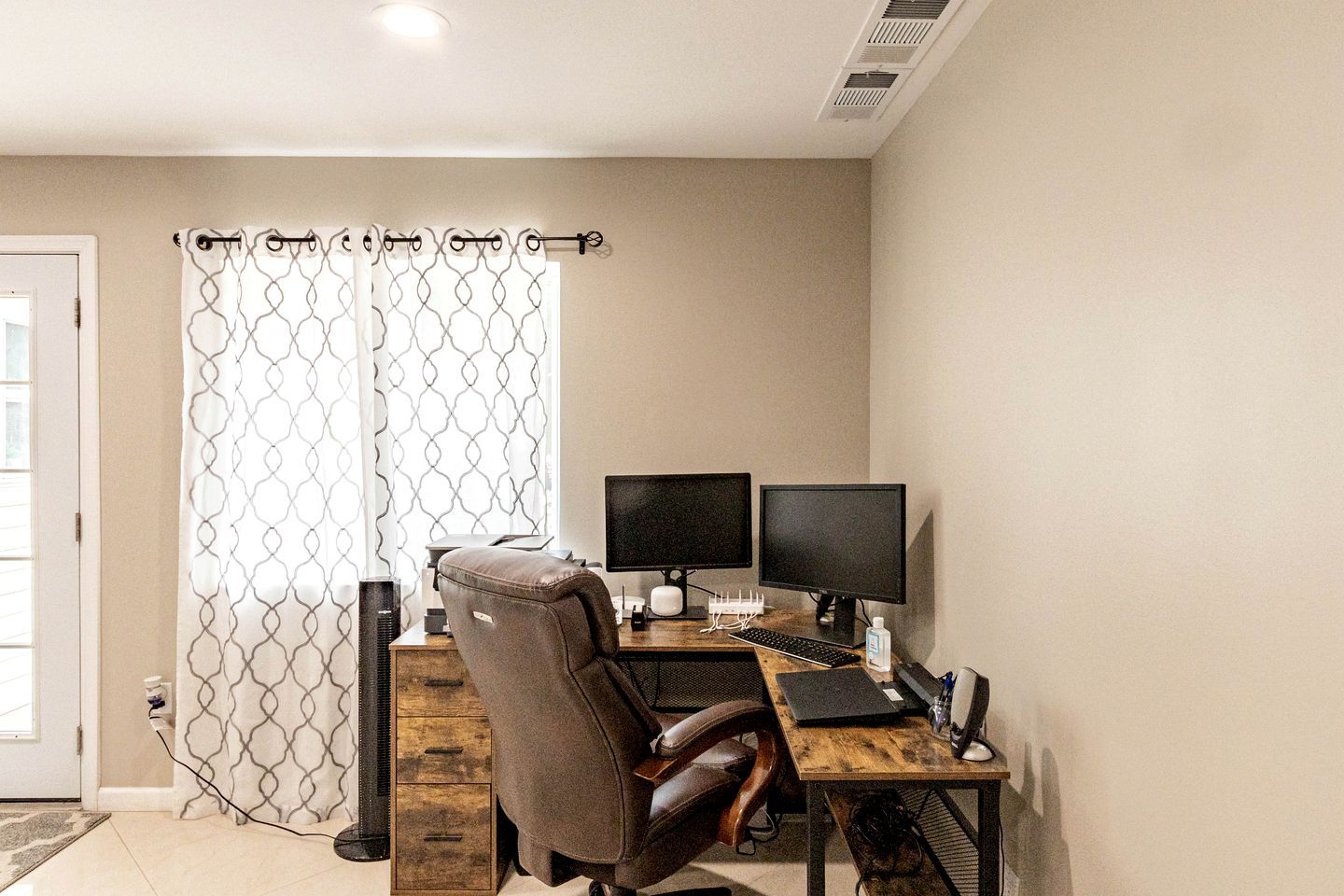 Un bureau à domicile équipé d’un bureau, de deux écrans, d’un clavier et d’une chaise.