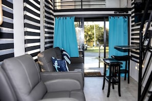 Una sala de estar moderna con un sofá, una mesita y una silla.
