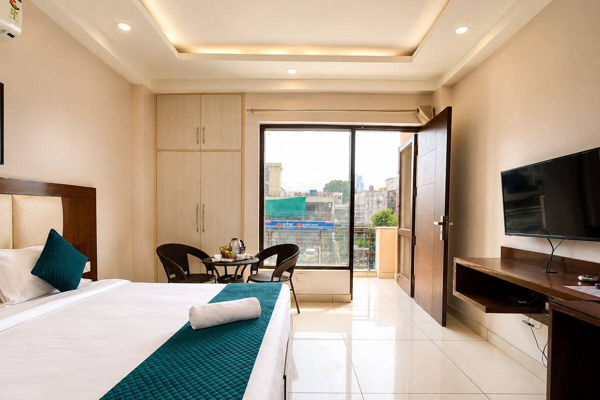 Une chambre d’hôtel comprenant un lit, une télévision, un bureau, une chaise, un balcon avec vue et une armoire.