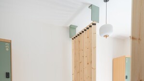 Ein Hotelzimmer mit zwei Betten, einer Holzwand, einer kleinen Sitzecke und einem Kleiderschrank.